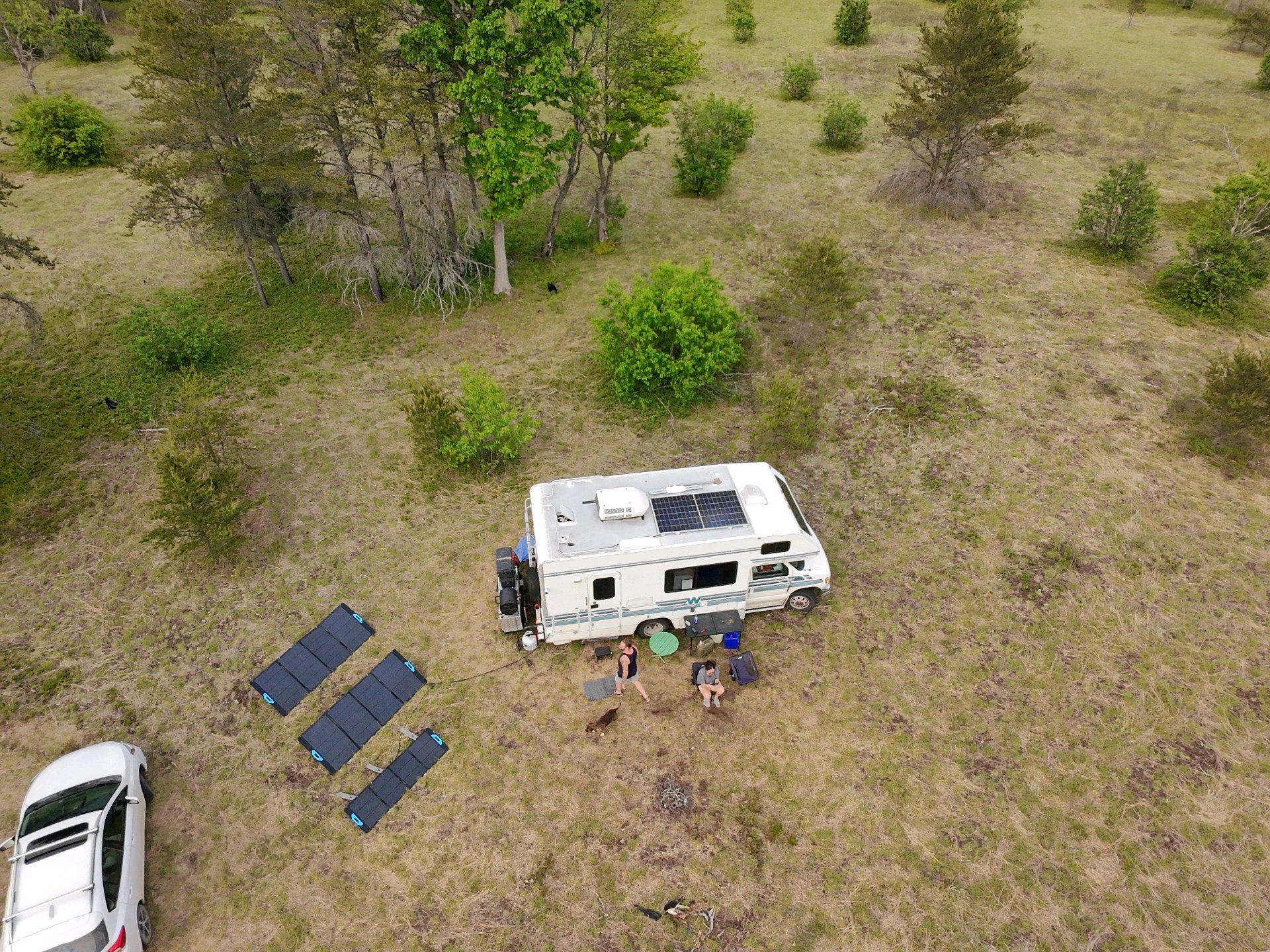 Aerial view of an off-grid RV and solar panels on rural land